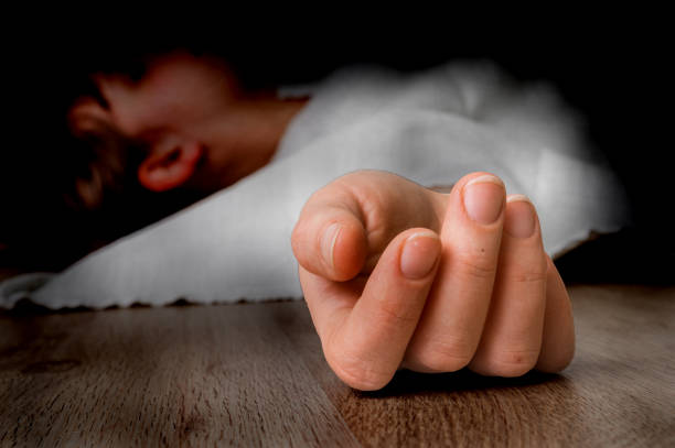 Dead woman lying on the floor under white cloth stock photo