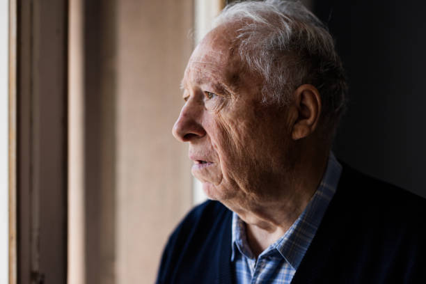 istock Lonely old man staring out of a window 648799548