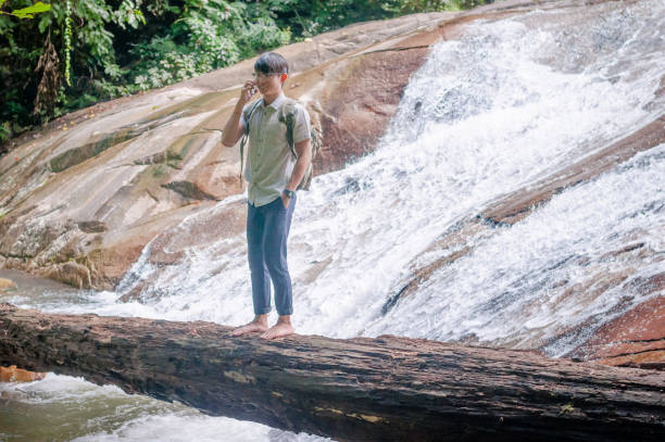 istock Hiker backpack with laptop and phone at  waterfall  the forest. 648803844