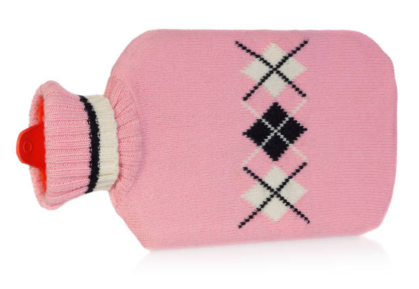 A hot water bottle in pink sweater with white and black patterns. Heater isolated on white background with light shadow and reflection.
