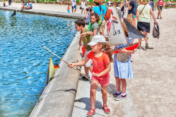 enfants flottent bateaux dans la fontaine du palais du luxembourg et le parc de paris, jardin l’un des plus beaux jardins de paris. france. - jardin luxembourg photos et images de collection