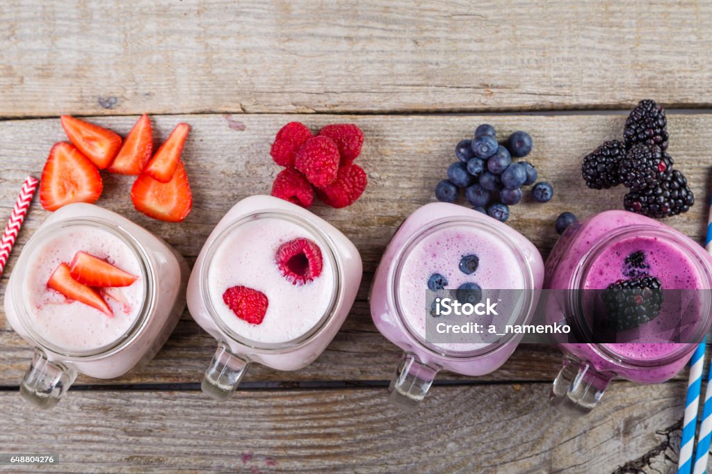 Selection of colorful detox berry drinks on wood background Selection of colorful detox berry drinks on wood background, copy space Smoothie Stock Photo