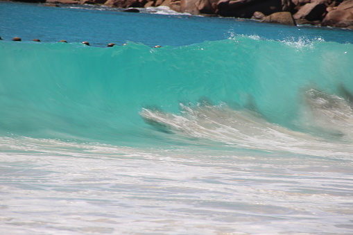 Extreme close up of powerful and bright aqua marine ocean wave barrelling on a shallow reef