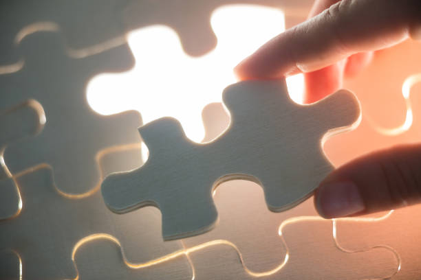 istock Woman placing missing piece in jigsaw puzzle 648832800
