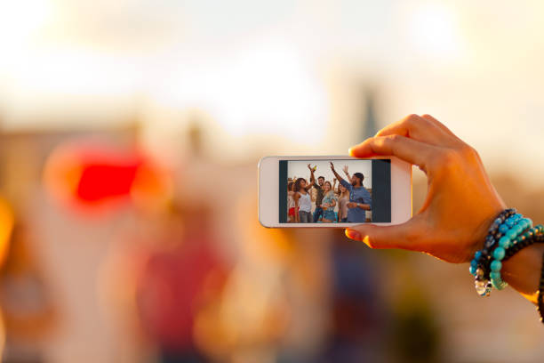 istock Woman photographing friends using smart phone 648833016