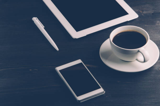 istock Coffee and gadgets on dark wooden background 648835288