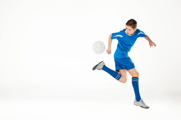 istock Young boy with soccer ball doing flying kick 648835328