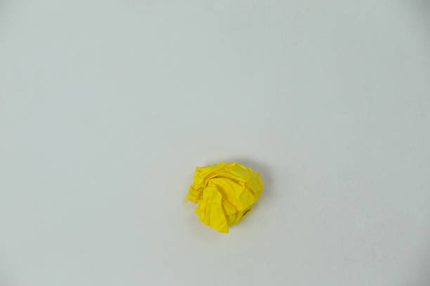 istock Yellow crumpled paper ball on a white background 648839906
