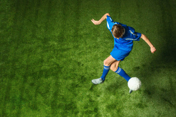 istock Young boy with soccer ball doing flying kick 648840816