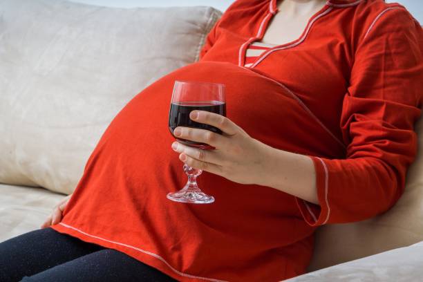 bere alcolici in gravidanza. una donna alcolizzata incinta beve vino. - abdomen addiction adult alcohol foto e immagini stock