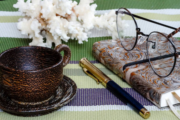 istock notebook with glasses and pen with, Cup on the table 648845084