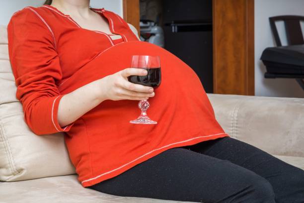 istock Pregnant alcoholic woman is drinking wine. 648845104