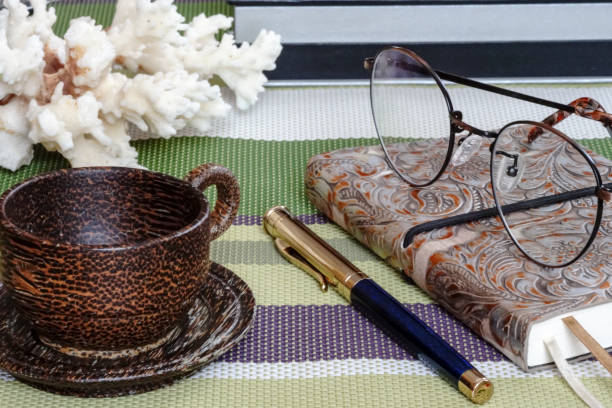 istock notebook with glasses and pen with, Cup on the table 648847816