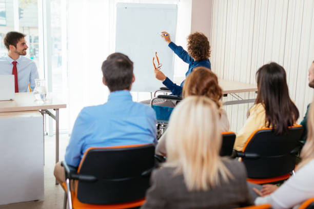 istock Handicapped adult student with lecturer in lecture hall, explaining on flipchart 648847956