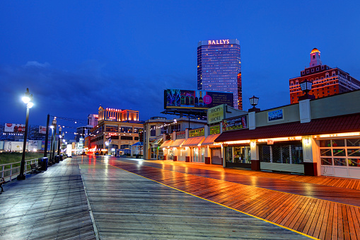 The Atlantic City casinos and Boardwalk along the oceanfront at night. Atlantic City located on the Jersey shore is a resort city on Absecon Island  in Atlantic County, New Jersey. Atlantic City is known for its two mile long boardwalk, gambling casinos, great nightlife, beautiful beaches, and the Miss America Pageant.