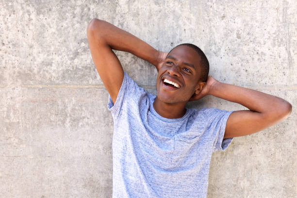 istock african man smiling in blue t-shirt with hands behind head 648855834