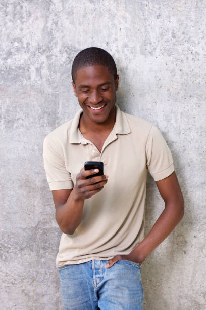 istock smiling african american man looking at mobile phone 648856274