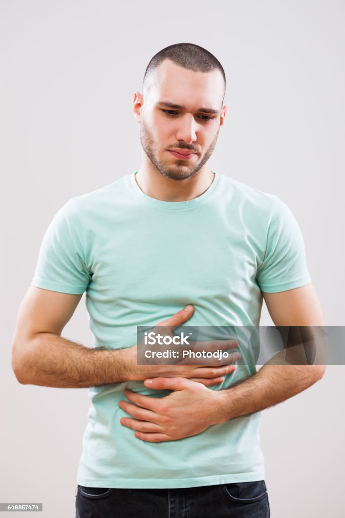 Man with diarrhea Young man is having pain in his stomach. Abdomen Stock Photo