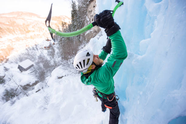 istock Portrait of ice climber hitting the ice with his axe 648867662