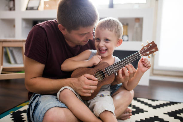 istock Cute little boy playing guitar with his daddy 648867826