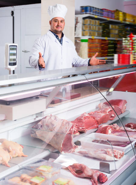 istock Young man near display with cooled meat 648867832