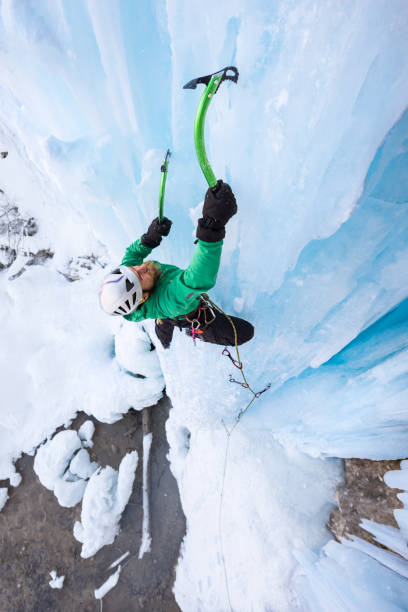 istock Determined male alpinist ice climbing on frozen waterfall 648868348