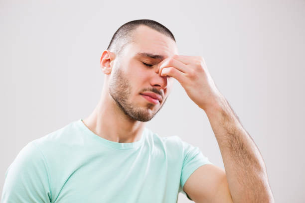 Man with allergy Portrait of young man who is having pain in his sinus. nose flower stock pictures, royalty-free photos & images