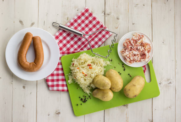 ingredientes para típica holandesa plato zuurkool con sauerkraut, smoked salchicha, bacon y patatas - sauerkraut cabbage vegetable white cabbage fotografías e imágenes de stock