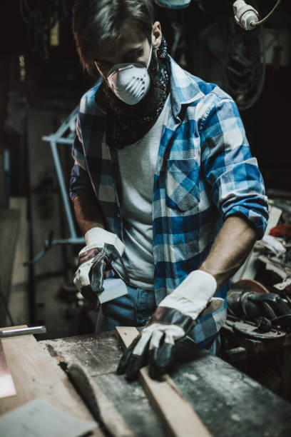 istock Young worker polishing wooden board at his workplace 648875382
