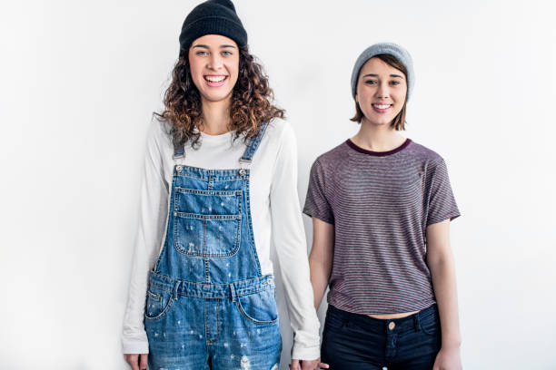 istock Smiling lesbian couple standing against white wall 648904682
