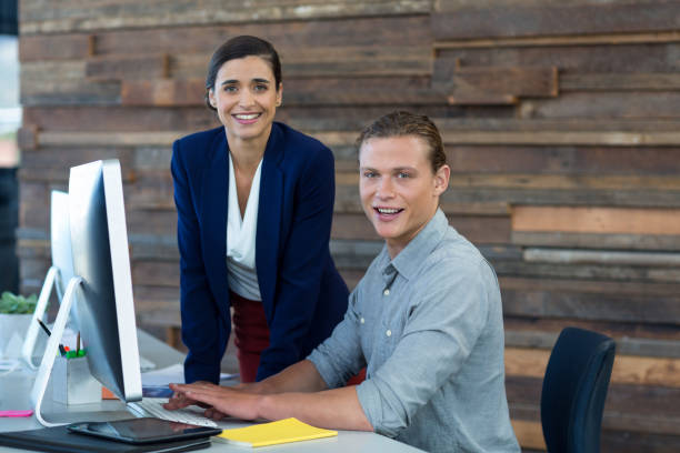 istock Portrait of smiling businesspeople working on personal computer 648918566