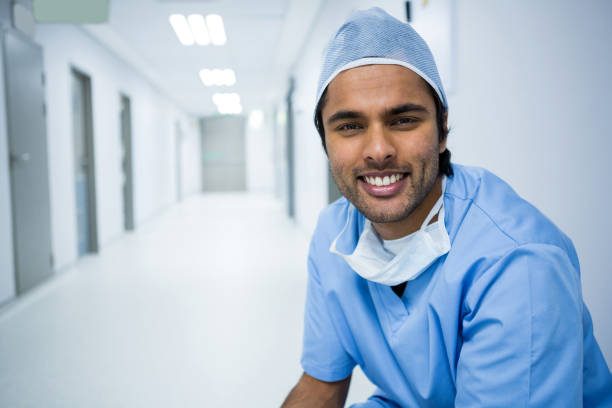 istock Portrait of smiling surgeon sitting in corridor 648923122