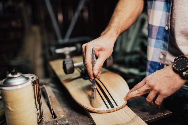 istock Man with a brush coating varnish on skateboard 648924296