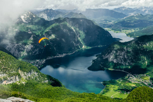 vuelo de libertad. con un paracaídas sobre las montañas y lagos. - paragliding sport austria parachuting fotografías e imágenes de stock