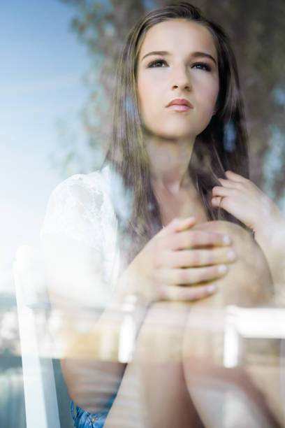 istock Young woman looking through glass window 648934382