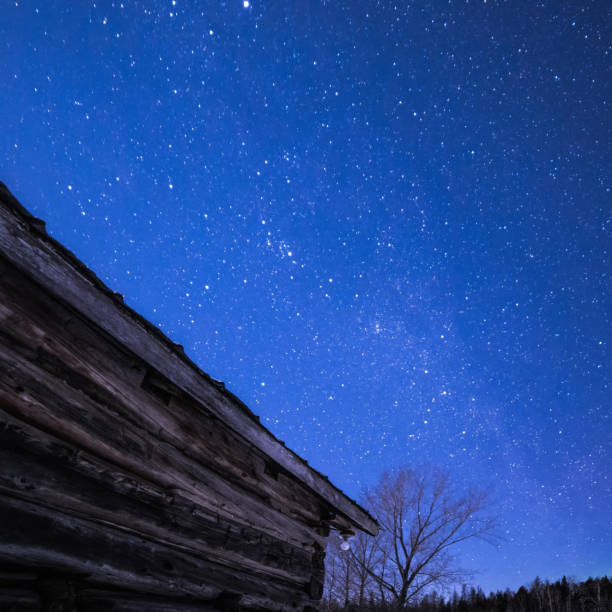 istock Log Cabin barn at night with stars and milky way 648941646