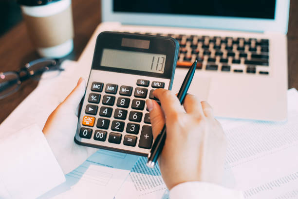 istock Female accountant using calculator at laptop 648942922