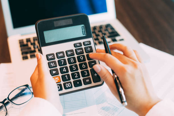 istock Female hands counting with calculator in office 648943128