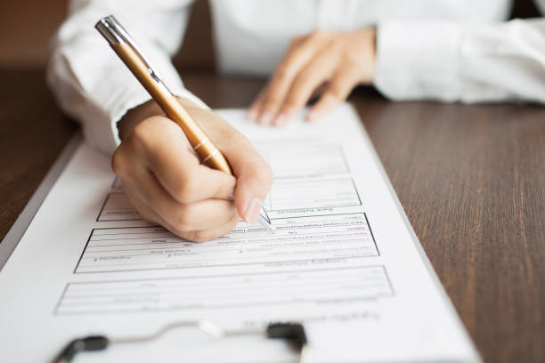 istock Businesswoman holding pen and reading document 648943142