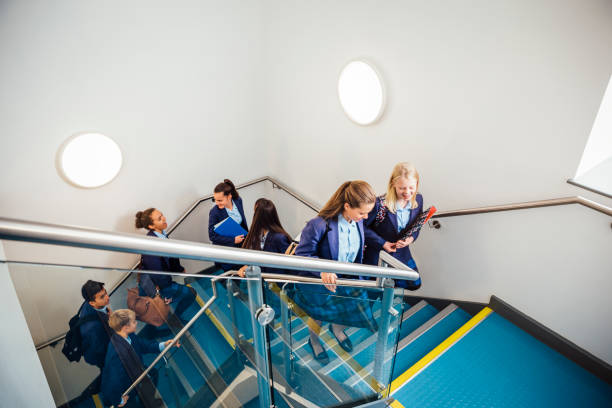 School Children Walking up School Staircase School friends make their way up the school staircase. One boy is carry a backpack. Wearing school uniform. View from above teenagers only teenager multi ethnic group student stock pictures, royalty-free photos & images