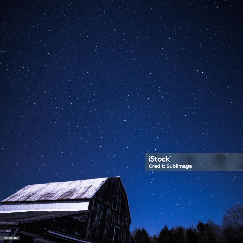 Granges rurales pendant la nuit avec des étoiles en hiver - Photo de La Charrue libre de droits