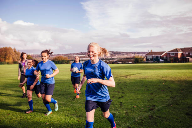 サッカー競技場をオフを実行している女の子 - soccer field dirty soccer outdoors ストックフォトと画像