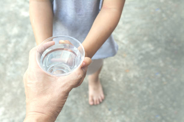parent hand give fresh water to child hands stock photo