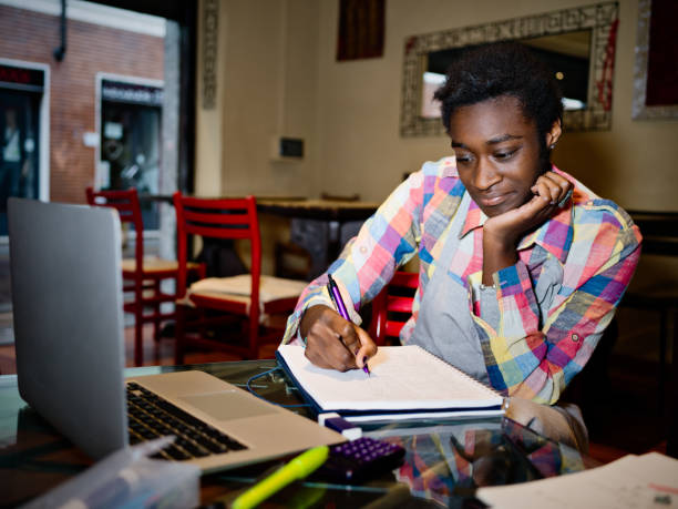 istock Young African waitress studying and having a break 648958108
