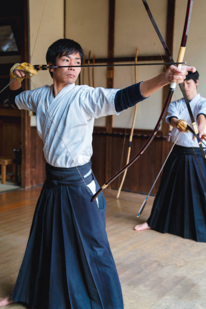日本弓は弓を発射する準備ができてを描画します - 弓道 ストックフォトと画像