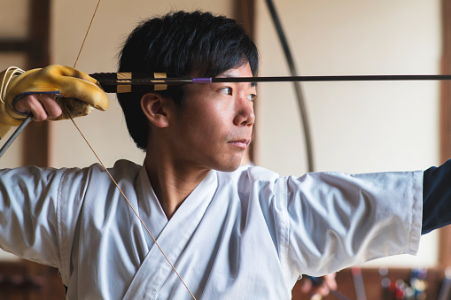 Japanese Kyudo archer draws his bow. Okayama, Japan. March 2017
