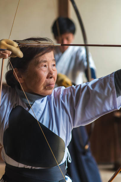 istock Senior Japanese archer preparing to take her shot 648967722