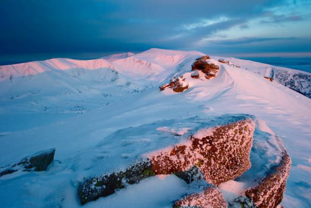 istock rock covered with snow and fog 648968128