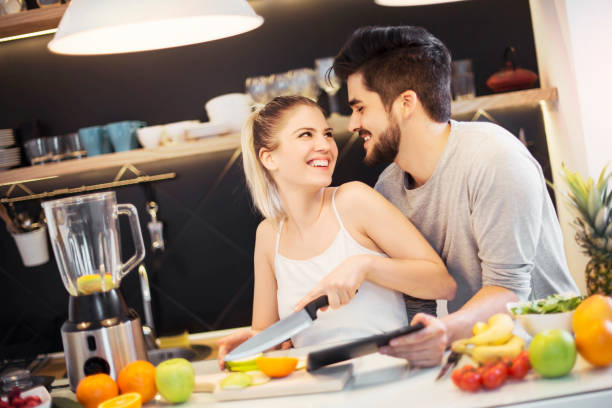 istock Young woman cutting fruit in the kitchen 648971366