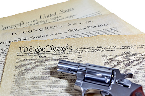 US Constitution with Bill of Rights and Declaration of Independence with a revolver
